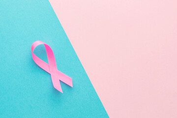 Breast Cancer concept : Top view pink ribbon symbol of breast cancer campaign on pink and bright blue