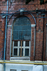 Antique stained glass window on an old red brick building