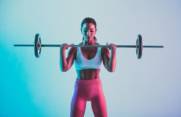 Fototapeta na wymiar Woman training with barbells in the gym