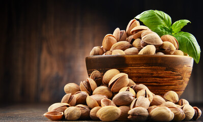 Bowl with pistachio on wooden table