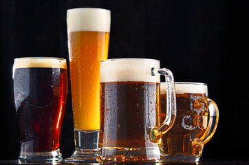 Four glasses of beer on wooden background