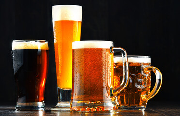 Four glasses of beer on wooden background