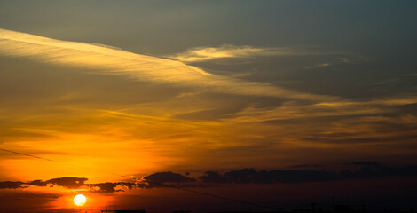 The sun sets over the horizon and illuminates the cloud on above oneself