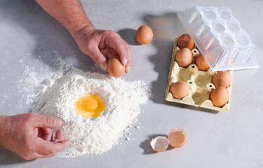 Male hands grabbing an egg with flour and eggshells