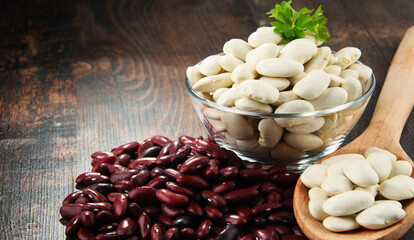 Composition with bowl of beans on wooden table