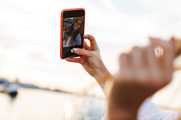 Image of laughing ginger woman smiling and taking selfie on mobile phone