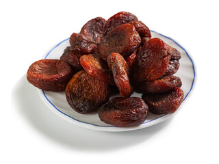 natural brown dried apricots on a white saucer with a blue border, isolated on a white background