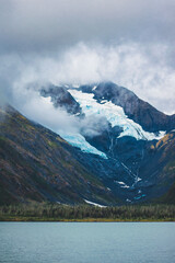 Mountain with hanging glacier beside a lake