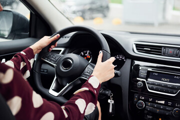 Close up view of beautiful young brunette that inside of modern automobile. Riding car