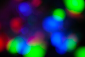 Red, green, pink, blue, blurry christmas and holiday lights in the dark. Multicolored, bright blurred bokeh background