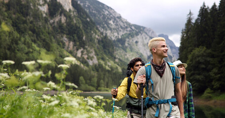 Group of young friends hiking in countryside. Multiracial happy people travelling
