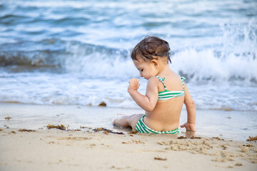 Girl Sitting In The Ocean Breaking Waves On The Sand Beach