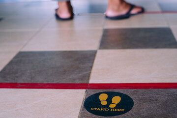 Stand here foot sign or symbol on the floor