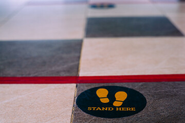 Stand here foot sign or symbol on the floor
