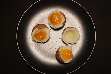 Egg halves in a black plate with salt