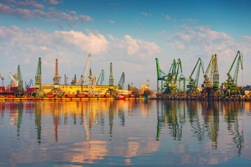 Fototapeta na wymiar Sea port and industrial cranes, Varna, Bulgaria. Sunrise over the Varna lake