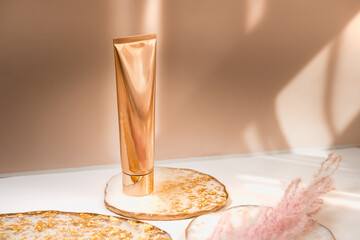 Golden cosmetic tube light pastel color background, lights and shadows. Natural minimalism look, clean sustainable concept. Minimal styling, still life. Beauty blogging, branding layout,  skin care ad - 370775730