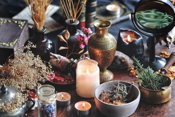Dried plants, herbs and yellow rose flower petals in a grey, dirty clay pot. Wiccan witch altar...