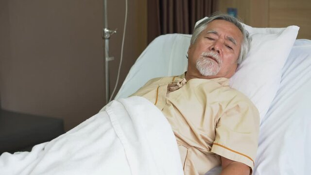 asian senior man patient lying on bed at hospital ward . Lonely old man  looking away in Nursing home