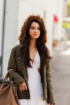 Beautiful young multicultural woman outdoors wearing a winter fur coat
