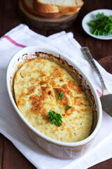 Dietary souffle of minced meat with parsley on a dark background.