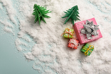 christmas presents nicely decorated with bows and feathers in snow. view from above.