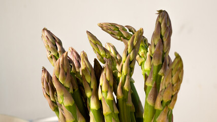 Isolated macro photo of the top of several green asparagus. This concept photo relates to healthy eating and a vegetarian lifestyle.