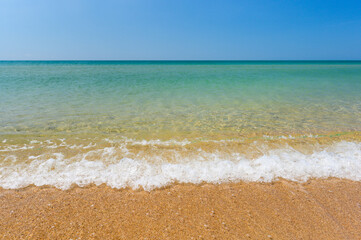 Sandy beach and clean transparent sea. Travel seascape.