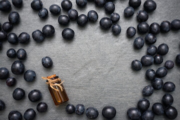 Grapes and grape essential oil juice on the gray table background with copy space.