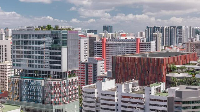 Singapore skyline with Victoria street and shoping mall aerial timelapse. Green trees on the road with traffic. Clouds on a blue sky