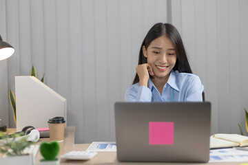 Young Asian woman working in an office with a smiling face is interested.