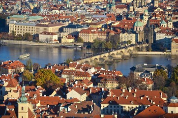 Prague city with Charles Bridge, aerial view towards river Moldau, sunny day in autumn