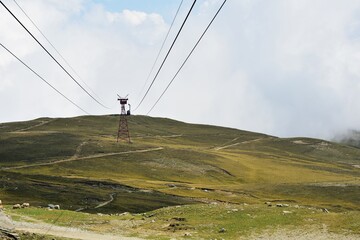 Obraz premium cable car on top of the mountain above the clouds