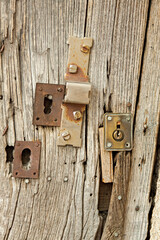 an old wooden door with three rusty iron locks