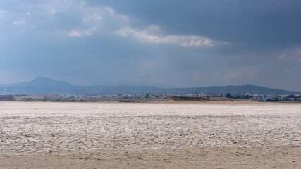 Surface of a dried salt lake against the background of clouds, Larnaca, Cyprus