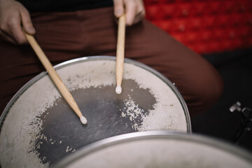 Close-up view of wooden sticks over drum. Shot of an unrecognizable man playing the drums using wooden sticks.