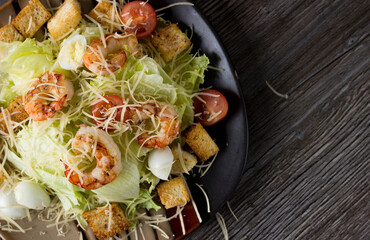 Caesar salad with prawns on a plate in a cafe