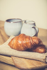 romantic breakfast with fresh croissants coffee,milk and berries on wooden table