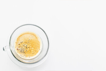 Full cup of fresh espresso, view from above. Cup of fresh espresso in glass cup on white background. Copy space with top view. Close up shot shows detail of beautiful bubbles. For business meetings