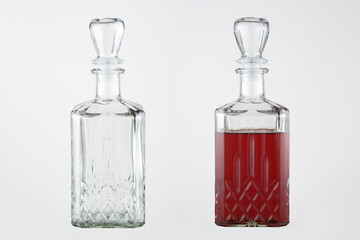 Homemade liqueur in a figured glass decanter with a glass stopper. A set of images on a gray background. Empty and full decanter.
