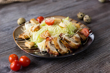 Caesar salad with chicken on a striped plate in a cafe