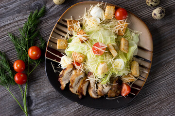Caesar salad with chicken on a striped plate in a cafe