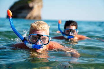 Happy friends men enjoying summer vacation and scuba diving