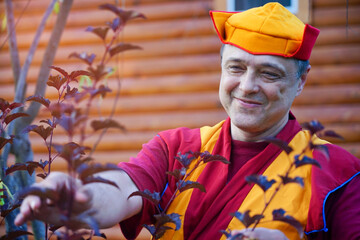 portrait of a monk in red clothes and a hat