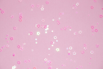 pink glittering stars on pink background close up