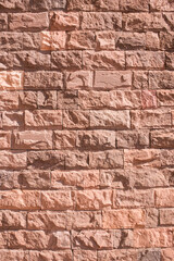 Red brick wall. Vertical decorative uneven blocks background. Urban architecture texture.