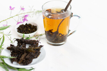 herbal tea cup with fermented fireweed leaves on white background