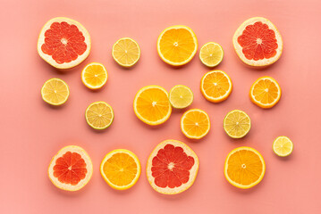 slices of grapefruit, orange, lime, on a pink surface. View from above