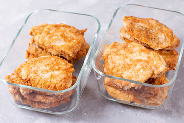 Fried meat in a glass container. Meal prepping. Ready meals