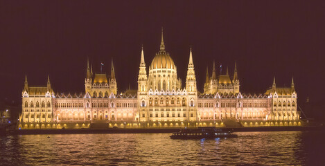 Fototapeta premium The Hungarian Parlament building at night in Budapestwith the Danube river